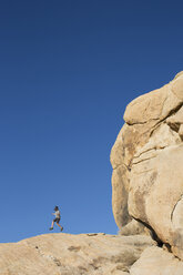 Junge, 7 Jahre, beim Wandern und Springen auf große Felsen in der Wüste. - AURF04393