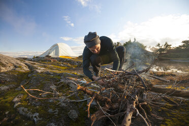 A Climber Starts A Fire Using Stick And Twig Found Around His Alpine Bivy - AURF04446