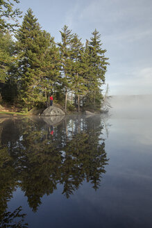 Ein Wanderer genießt die kühle Morgenluft an einem See in Vermont. - AURF04466