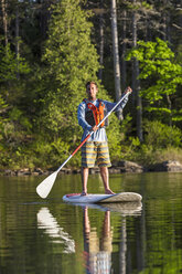 Ein Mann paddelt auf einem langen Teich in der Nähe von Greenville, Maine - AURF04504