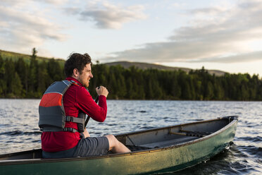 Ein Mann paddelt sein Kanu auf dem Long Pond in den nördlichen Wäldern von Maine nahe Greenville, Maine - AURF04507