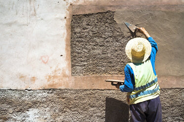 Ein Maurer repariert einen Teil der alten Mauer, die die Altstadt von Marrakesch umgibt - AURF04515