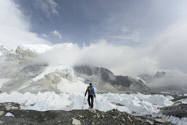A trekker stands over the Khumbu Glacier in Everest Base Camp. - AURF04525