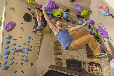 A Multi-ethnic Couple Training In Their Home Climbing Gym - AURF04527