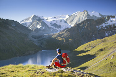 Ein einsamer männlicher Wanderer genießt den Blick auf den Lac des Dix im Val d'H├â┬®r├â┬®mence in den Schweizer Alpen. - AURF04533