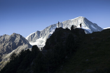 Ein alleinstehender männlicher Wanderer wandert über einen Bergkamm oberhalb von Arolla in den Schweizer Alpen. - AURF04534
