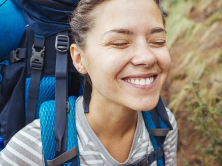 Eine lächelnde Frau mit einem Rucksack Wandern im Wald - AURF04573