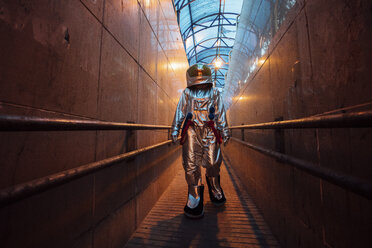 Spaceman in the city at night walking in narrow passageway - VPIF00651