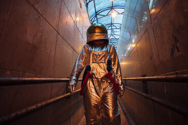 Spaceman in the city at night in narrow passageway - VPIF00652