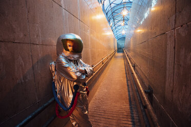 Raumfahrer in der nächtlichen Stadt in einem engen Durchgang stehend - VPIF00654