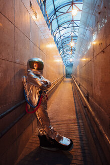 Raumfahrer in der nächtlichen Stadt in einem engen Durchgang stehend - VPIF00655