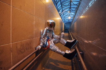 Raumfahrer in der Stadt bei Nacht mit Kaffee zum Mitnehmen in einer engen Passage - VPIF00660