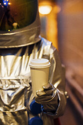 Raumfahrer in der Stadt bei Nacht mit Kaffee zum Mitnehmen - VPIF00663