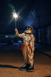 Spaceman standing outdoors at night holding sparkler - VPIF00700