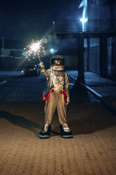 Spaceman standing outdoors at night holding sparkler - VPIF00702