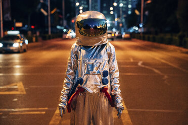 Raumfahrer, der nachts auf einer Straße in der Stadt steht - VPIF00708