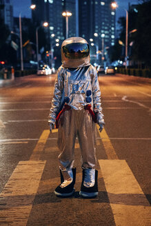 Raumfahrer, der nachts auf einer Straße in der Stadt steht - VPIF00710