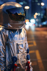 Spaceman standing on a street in the city at night - VPIF00714