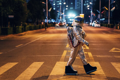 Raumfahrer, der nachts auf einer Straße in der Stadt geht - VPIF00715