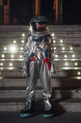 Spaceman standing at illuminated stairs at night - VPIF00758