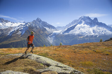 Ein junger männlicher Läufer auf einer Alm in der Nähe von Chamonix mit der spektakulären Mont-Blanc-Kette im Hintergrund. - AURF04589
