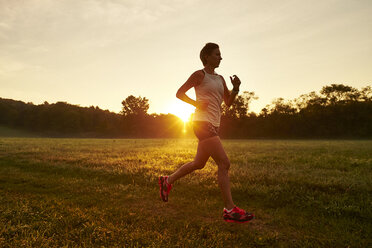 Young woman jogging, low angle view stock photo