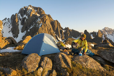 Eine Frau bei der Essenszubereitung beim Zelten auf dem Blaine Peak unterhalb des Mount Sneffels - AURF04623