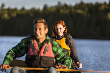 Ein junges Paar paddelt ein Kanu durch Morgennebel auf Long Pond, Greenville, Maine - AURF04656