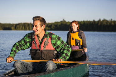 A Young Couple Paddles A Canoe Through Morning Mist On Long Pond Near Greenville, Maine - AURF04662