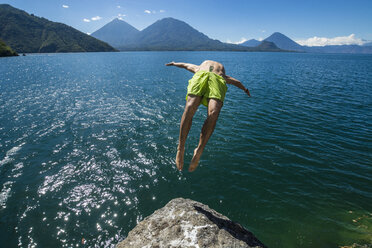 A young strong male does a backflip off a rock into Lake Atitlan, Guatemala. - AURF04681