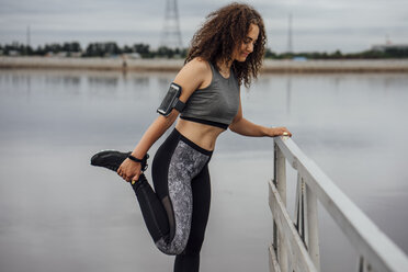 Young athletic woman stretching at the riverside - VPIF00764