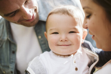 Parents holding cute baby boy looking at camera - CAIF22019