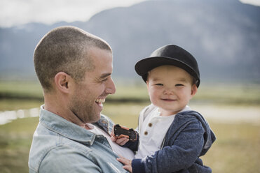 Father holding cute, happy baby son looking at camera - CAIF22026