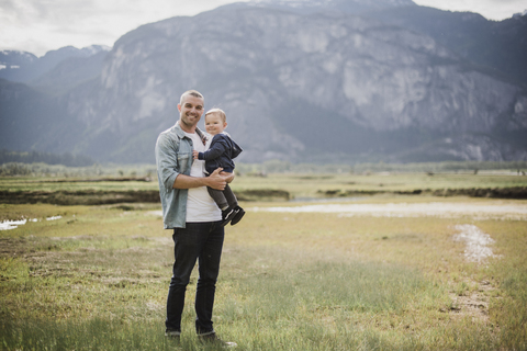Porträt Vater und kleiner Sohn stehen in einem ländlichen Feld, lizenzfreies Stockfoto