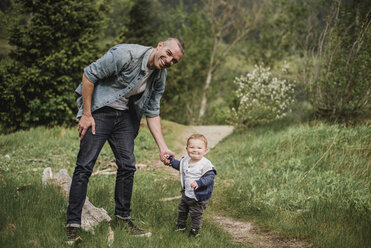 Porträt Vater und Baby Sohn zu Fuß auf grasbewachsenen Weg - CAIF22028