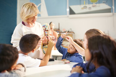 Lehrerin und neugierige Schüler mit anatomischem Modell im Wissenschaftszentrum - CAIF22089