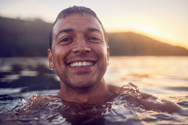 Close up portrait smiling, carefree man swimming in ocean - CAIF22139