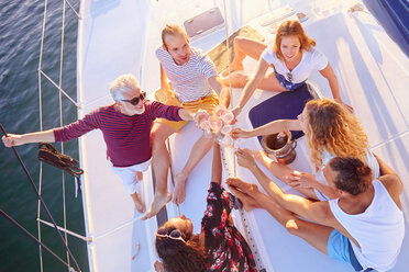 Blick von oben Freunde stoßen auf einem sonnigen Boot mit Champagner an - CAIF22142