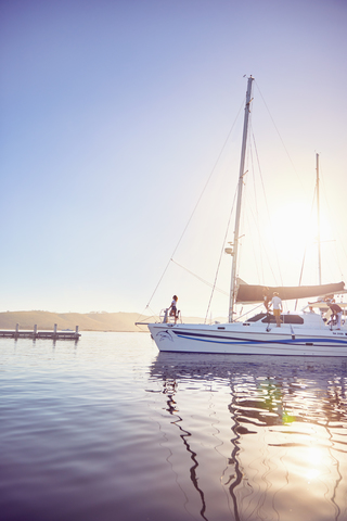 Menschen auf einem Boot im sonnigen Hafen, lizenzfreies Stockfoto