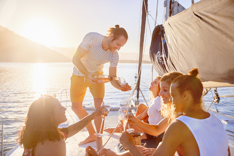 Friends drinking champagne on sunny catamaran stock photo