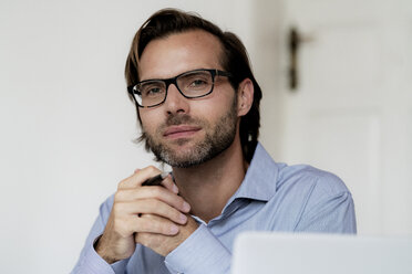 Porträt eines selbstbewussten Mannes mit Brille und Stift in der Hand - HHLMF00380