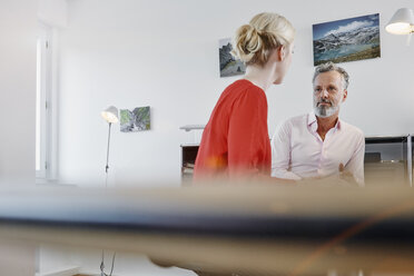 Zwei Kollegen unterhalten sich am Schreibtisch im Büro - RHF02092