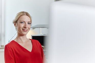 Porträt einer lächelnden jungen Frau im Büro - RHF02114