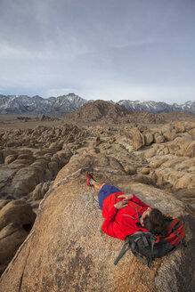 Mann entspannt sich auf einem Felsen in den Alabama Hills am Fuße der Sierra Nevada - AURF04705