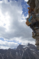 Bergführer hilft einer Bergsteigerin beim Aufstieg über die Felswand - AURF04720