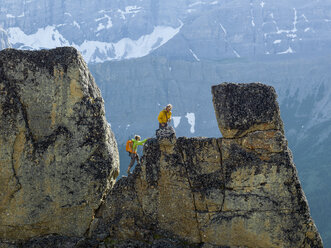 Mountaineering couple ascend rock pinnacle, mountains - AURF04724