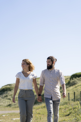 Young couple taking a walk in the dunes stock photo
