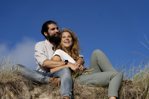 Young couple sitting on a dune in summer, relaxing - HHLMF00417