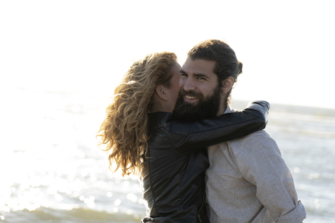Glückliches Paar umarmt sich am Strand, lizenzfreies Stockfoto