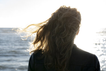 Blonde Frau schaut auf das Meer, Rückansicht - HHLMF00443